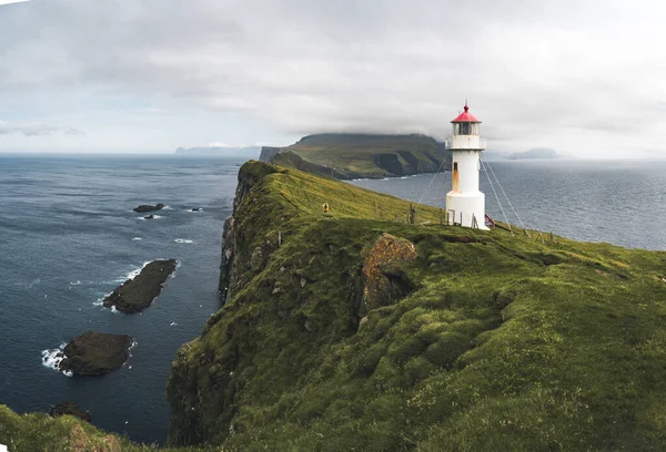 View Towards Lighthouse on the island of Mykines Holmur, Faroe Islandson a cloudy day with view towards Atlantic Ocean. — Stock Photo, Image