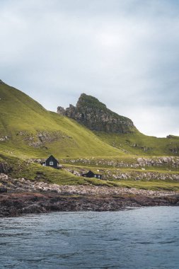 Arka planda ikonik Drangarnir kapısı, Tindholmur ve benim kines adası, Faroe Adaları ile üst görünüm dikey kompozisyonu