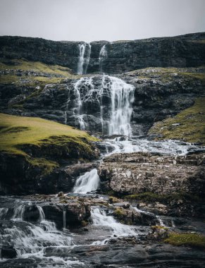 Faroe adalarındaki Saksun köyündeki şelaleler. Etrafta insan yok, geleneksel taş evler..