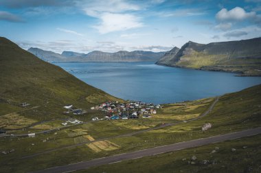 Funningur köyü yakınlarındaki Faroe Adaları 'ndaki manzaralı fiyortların güneşli bir bahar günü karla kaplı dağlarıyla muhteşem manzarası..