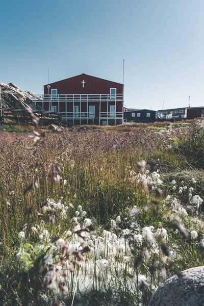 Típica casa de pescadores de madera colorida con iceberg en la bahía de Disko Groenlandia e Ilulissat. Arquitectura típica en el círculo ártico. Verano y cielo azul. — Foto de Stock