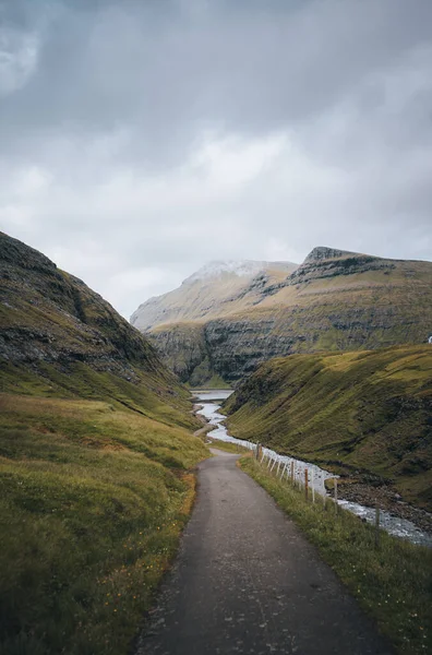 Faroe Adaları 'ndaki kayalıkları, kayaları ve yüksek kayalıkları olan nehir deltası, güneşli bir bahar sabahı, Streymoy adasının Saksun köyüne yakın. Destansı İskandinav doğası.
