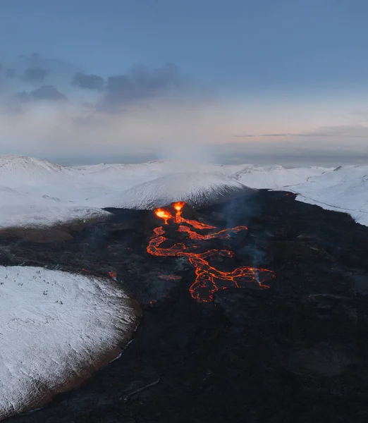Aerial Panorama van actieve lava rivier stroomt van een vulkanische uitbarsting in de berg Fagradalsfjall Geldingadalir vallei, Zuidwest IJsland. Blauwe lucht met sneeuwbergen. De uitbarsting is aan de gang sinds maart — Stockfoto