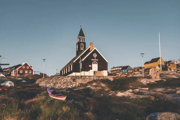 Starý dřevěný kostel Sions v arktickém městě Ilulissat, s půlnočním sluncem a modrou oblohou v severním Grónsku — Stock fotografie