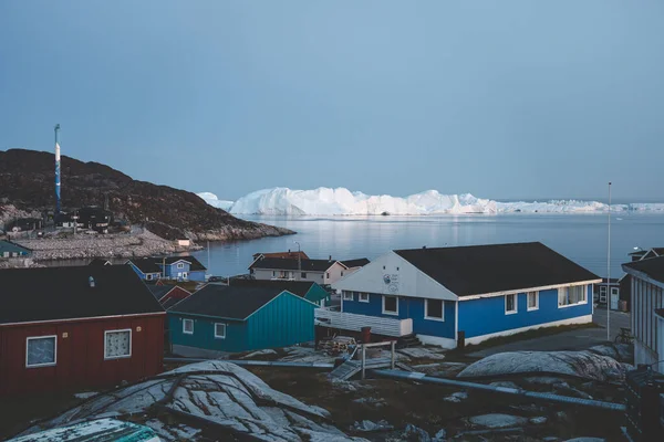 August 18 2019, Ilulissat, Greenland. View across colorful houses along the main street of Ilulissat, located on the westcoast of Greenland. Kangia icefjord visible in the background. — Stock Photo, Image