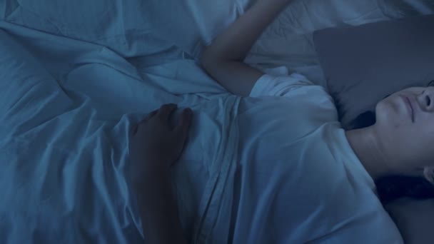 Adolescente che soffre di insonnia sdraiato a letto di notte — Video Stock