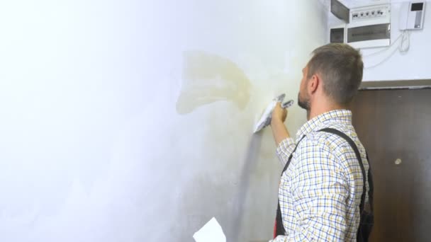 Young handsome male builder lays plaster on the wall with a trowel. home repairs — Stock Footage Young handsome male builder lays plaster on the wall with a trowel. home repairs Royalty Free Stock Footage