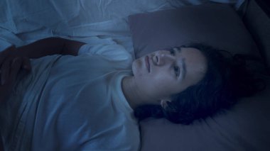Genç çocuk uykusuzluktan muzdarip. Geceleri yatakta yatıyor.