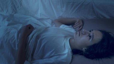 Genç çocuk uykusuzluktan muzdarip. Geceleri yatakta yatıyor.