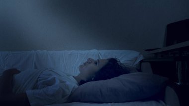 Genç çocuk uykusuzluktan muzdarip. Geceleri yatakta yatıyor.