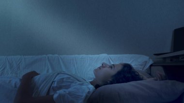Genç çocuk uykusuzluktan muzdarip. Geceleri yatakta yatıyor.