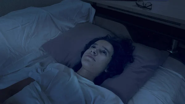 Хлопчик-підліток, який страждає від безсоння лежить в ліжку вночі — стокове фото