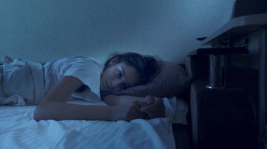 Uykusuzluktan muzdarip genç bir kızın portresi. Geceleri yatakta yatıyor..