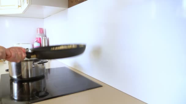 Крупним планом. жіночі руки перетворюють пельмені на сковороду, що кидає їх — стокове відео