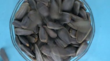 Son derece yakın plan, detaylı. Siyah ayçiçeği çekirdeği yığının içine düşer.