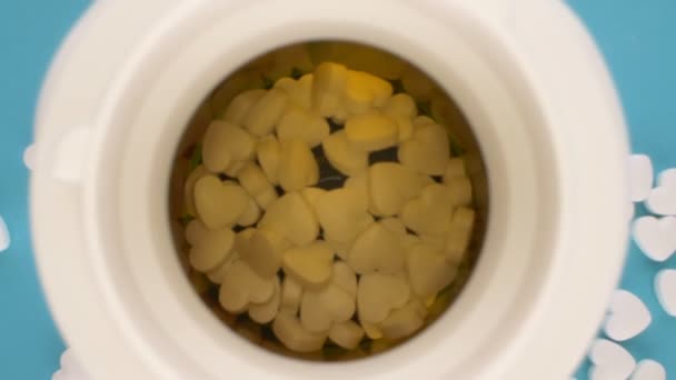 Extremamente close-up, detalhado. pílulas em forma de coração branco em uma garrafa — Vídeo de Stock