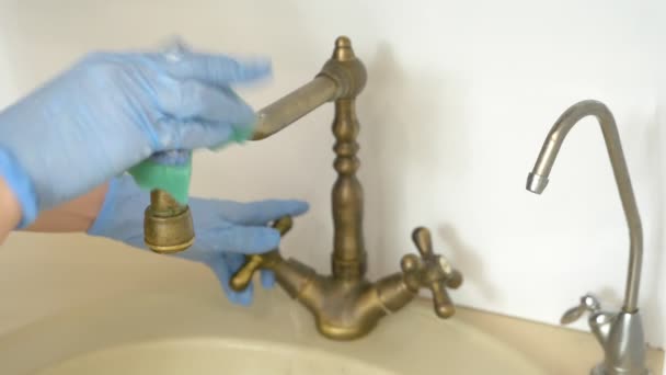Mãos femininas em luvas de borracha lavar uma torneira de latão com água na cozinha — Vídeo de Stock