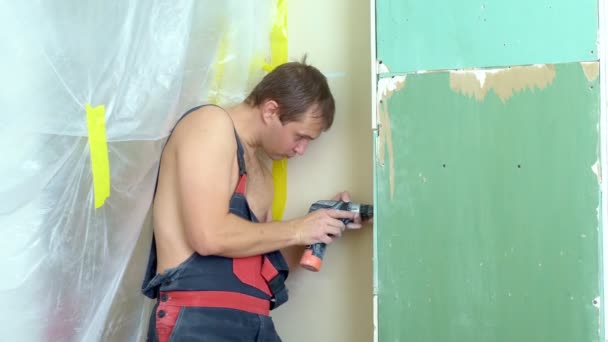 작업복을 입은 남자가 스 크류 드라이버 를 가지고 벽에 소켓 을 삽입 한다 — 비디오