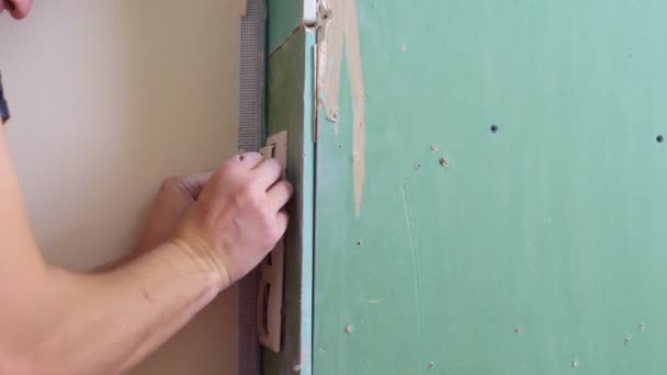 Muž v montérkách vloží zásuvku do stěny šroubovákem — Stock video