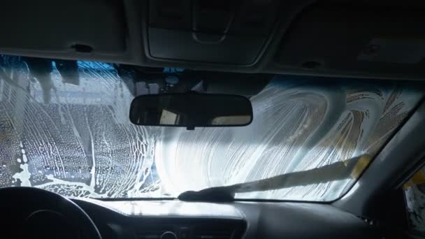 Pohled zevnitř auta. muž myjící auto v myčce aut — Stock video