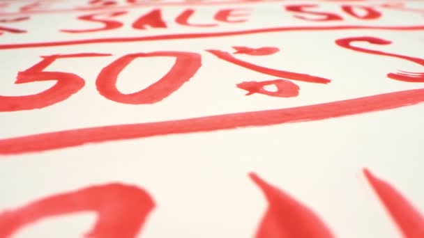 Background with repeating inscriptionfifty percent SALE written in red paint — Stock Video