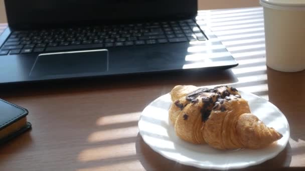 커피와 패스트 푸드용 일회용 컵이 있는 책상. 노트북 컴퓨터를 열고. 아침은 사무실에서 먹고 — 비디오