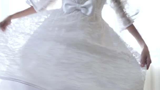 Yakın plan, 4K, yavaş çekim, kız beyaz dantelli bir elbise içinde dönüyor.. — Stok video