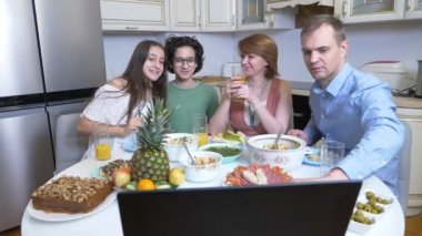 Aile tatilini bir dizüstü bilgisayarın önünde bir sette oturarak kutluyor. 