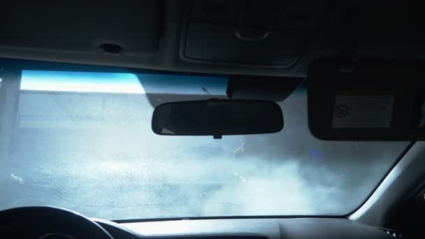Vedere din interiorul maşinii. Un bărbat care spală o mașină la o spălătorie auto — Videoclip de stoc