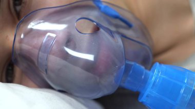  Hastanede yatakta yatan bir adamın yüzünde oksijen maskesi vardı.