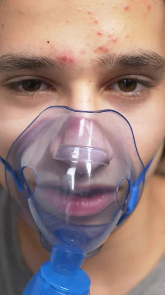 Syrgasmask i ansiktet på en kille som ligger på en säng på ett sjukhus — Stockfoto
