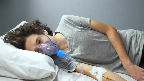 Rozmazané pozadí. muž s kyslíkovou maskou a kapátkem na nemocniční posteli — Stock fotografie
