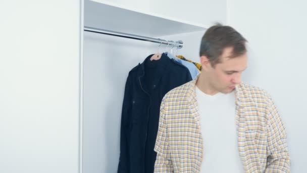 Hombre sonriente guapo abre armario con ropa, espacio de copia — Vídeos de Stock