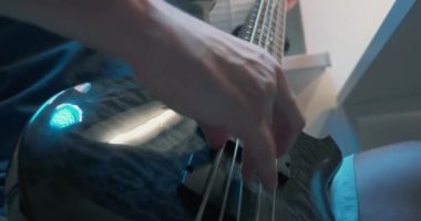 Aşırı yakın plan, detaylı. erkek eli bas gitar çalıyor