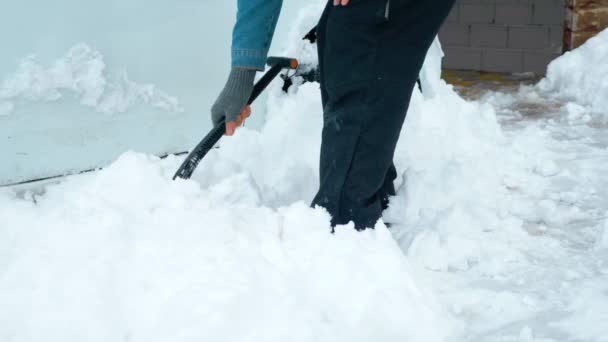 Kopiera utrymme. en man som skottar en bil från snö på gården — Stockvideo