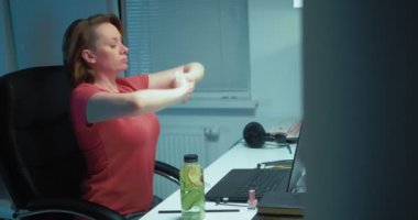 Sağlıklı bir yaşam tarzı. Kadın evinde, masasında otururken ısınıyor.