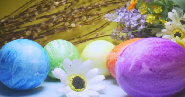 Détail extrême gros plan des œufs multicolores de couleur sur une assiette avec des fleurs et saule chatte. fond jaune. décorations de Pâques — Video