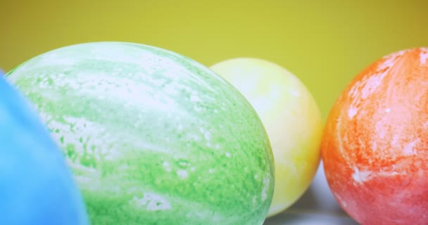 Detallado primer plano extremo de huevos multicolores en un plato. fondo amarillo. decoraciones de Pascua — Vídeos de Stock