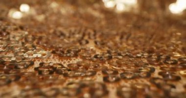 Soyut tekstil arka planı. Kumaştaki altın pulların detaylı yakın plan çekimi