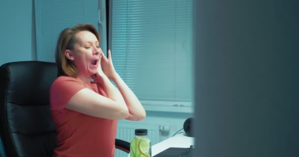 Frau macht Gesichtsgymnastik mit Laptop zu Hause im Büro — Stockvideo