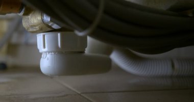 close-up of leaking bathroom siphon, apartment flooding concept