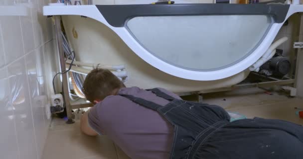 Mann repariert moderne Badewanne im Badezimmer, Sanitär — Stockvideo