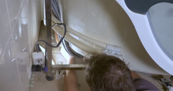 Closeup, man repairing modern bathtub in bathroom, plumbing — Stockvideo