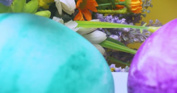 Detailed extreme close-up, colorful Easter eggs with a bouquet of color on a yellow background — Stock Video