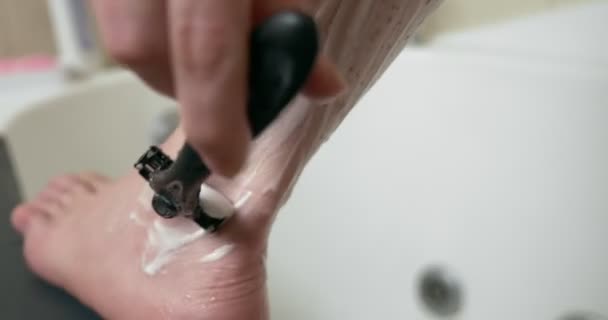 特写。现代浴室里的女人用泡沫和剃须刀刮腿 — 图库视频影像