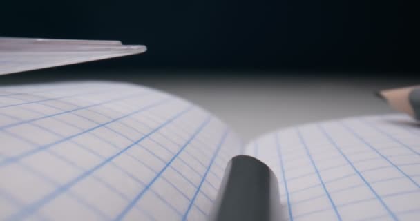 Szczegółowe ekstremalne zbliżenie notebooka w kratkę z ołówkami i kompasami — Wideo stockowe