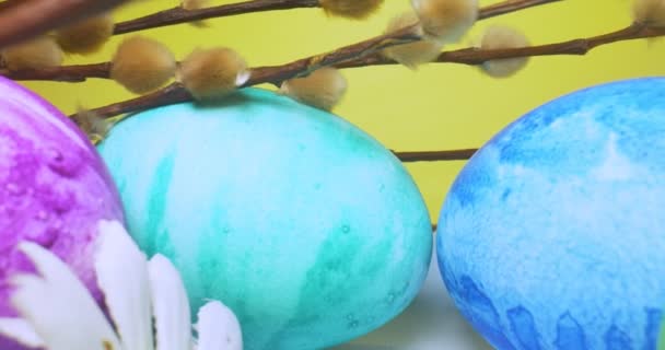 detailed extreme close-up, colorful easter eggs with pussy willow branches on yellow background