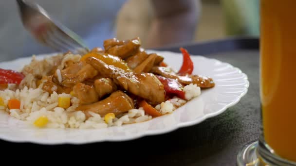 Крупный план риса с курицей со сладким и кислым соусом. Кто-то ест рис вилкой — стоковое видео
