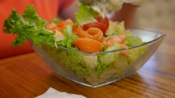 Женщина крупным планом ест салат Цезарь с лососем и вилкой — стоковое видео