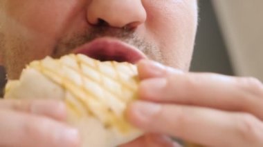 Kafede vejetaryen shawarma yiyen bir adamın yüzünü yakından çek.